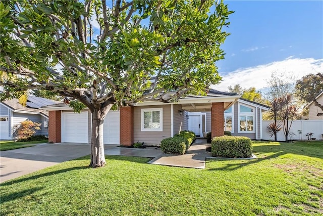 view of front of house with an attached garage, concrete driveway, a front yard, and fence