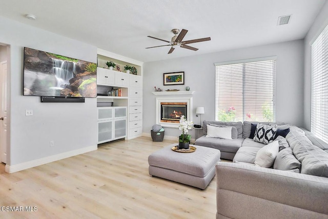 living room featuring light hardwood / wood-style floors and ceiling fan