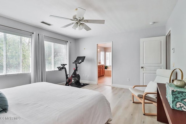 bedroom featuring multiple windows, light hardwood / wood-style floors, ceiling fan, and ensuite bathroom