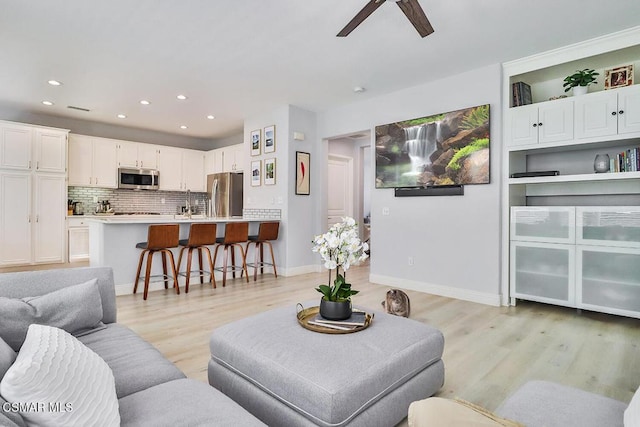 living room featuring light hardwood / wood-style floors and ceiling fan