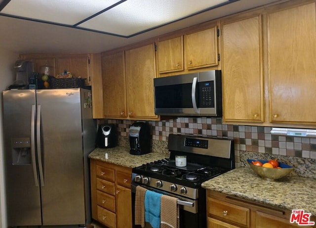 kitchen featuring tasteful backsplash, stainless steel appliances, and light stone counters