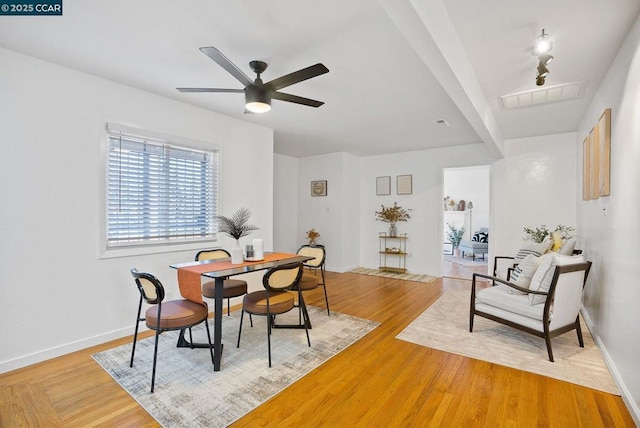 dining space with ceiling fan and light wood-type flooring