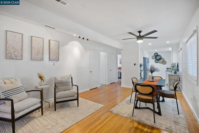 dining room with ceiling fan and light wood-type flooring