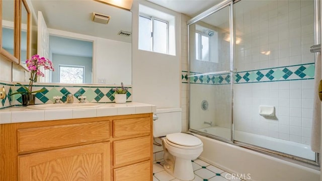 full bathroom with tasteful backsplash, vanity, enclosed tub / shower combo, and toilet