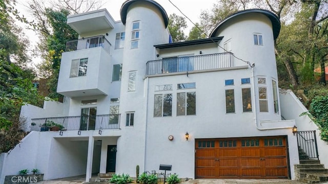 view of front of home with a balcony and a garage