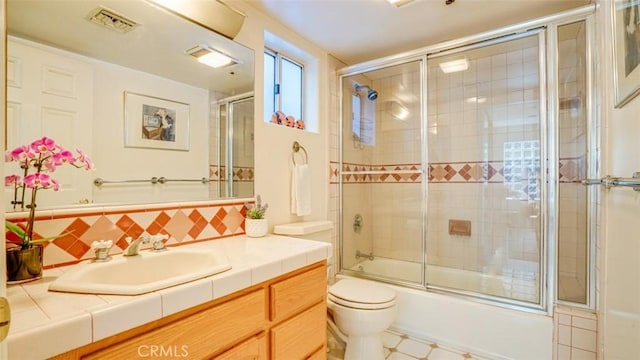 full bathroom featuring enclosed tub / shower combo, toilet, vanity, and decorative backsplash