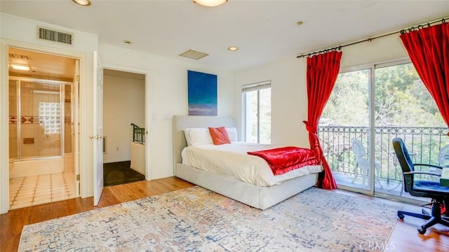 bedroom featuring wood-type flooring, access to outside, and ensuite bath