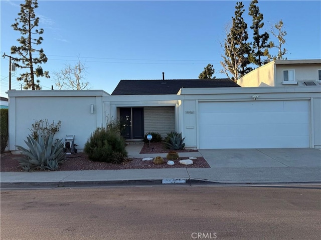 view of front of property featuring stucco siding, an attached garage, and concrete driveway