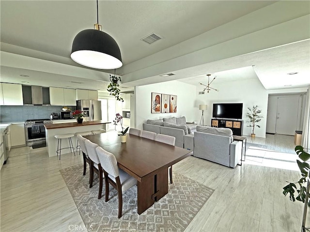 dining room with visible vents and light wood-type flooring