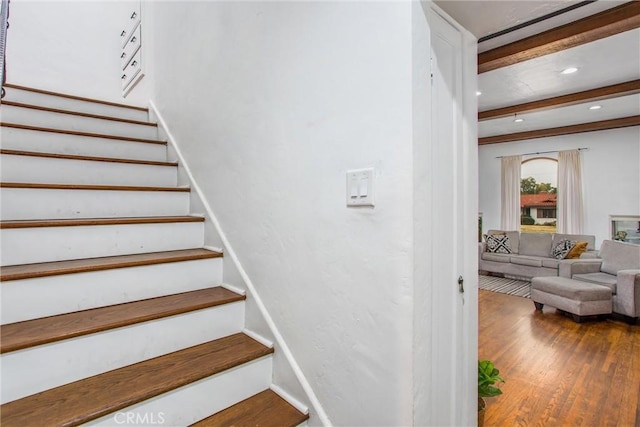 staircase with beam ceiling and wood-type flooring