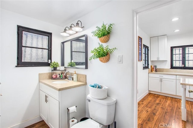 bathroom featuring wood-type flooring, vanity, and toilet