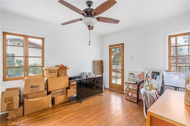 office area with wood-type flooring, a healthy amount of sunlight, and ceiling fan