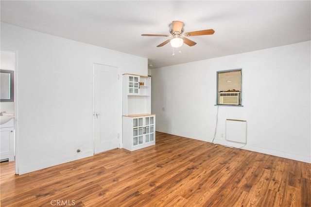 spare room with wood-type flooring, cooling unit, and ceiling fan