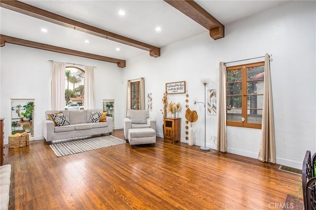 living area featuring wood-type flooring and beam ceiling