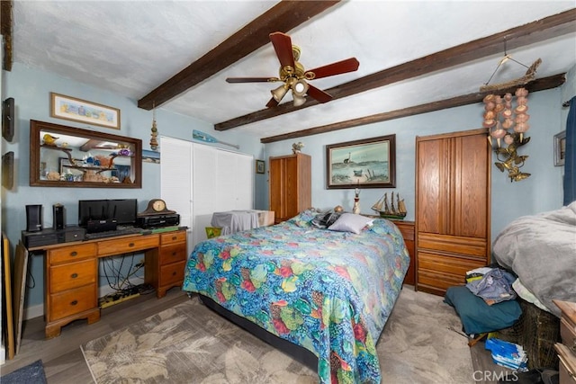 bedroom featuring ceiling fan, a closet, and beam ceiling