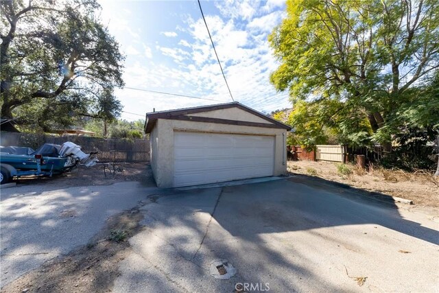 detached garage featuring fence