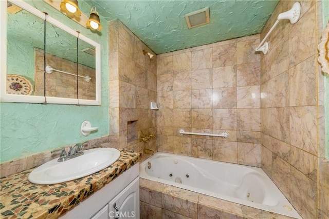 full bath featuring a textured ceiling and vanity