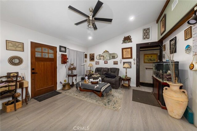 living room with light wood-type flooring, vaulted ceiling, a ceiling fan, and recessed lighting