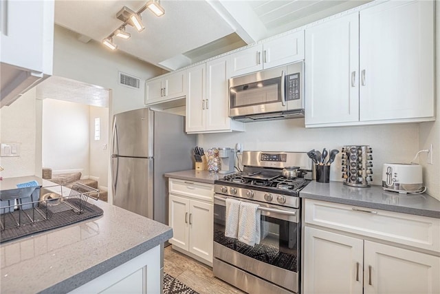 kitchen with stainless steel appliances, white cabinetry, rail lighting, and light hardwood / wood-style flooring