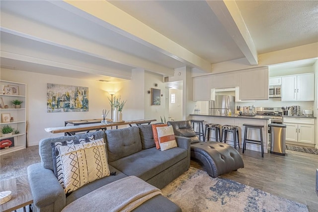 living room featuring beam ceiling and light hardwood / wood-style flooring