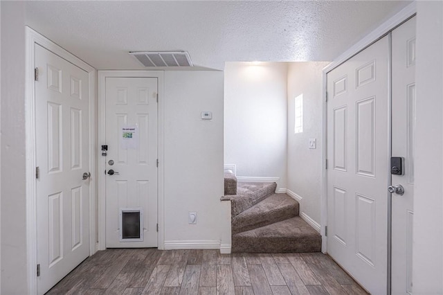 entryway with hardwood / wood-style flooring and a textured ceiling