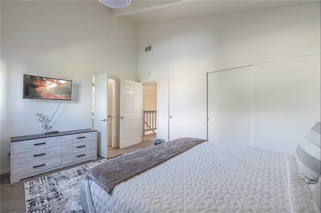 bedroom featuring beam ceiling, high vaulted ceiling, and carpet