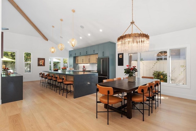 dining space with high vaulted ceiling, a notable chandelier, beam ceiling, and light hardwood / wood-style flooring