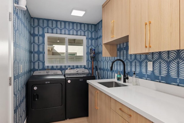 clothes washing area featuring cabinets, separate washer and dryer, and sink