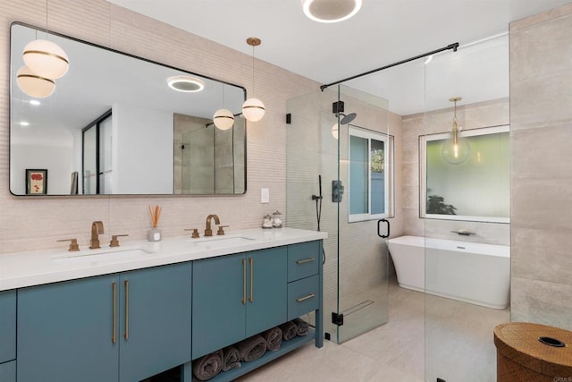 bathroom featuring tile patterned floors, separate shower and tub, tile walls, vanity, and backsplash