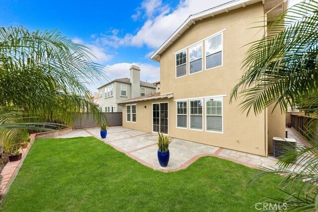 rear view of house featuring a yard, a patio area, and central AC