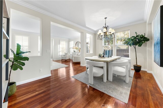 dining space featuring crown molding, a chandelier, and dark hardwood / wood-style flooring