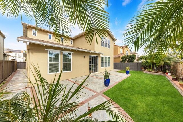 back of property with a patio area and a lawn