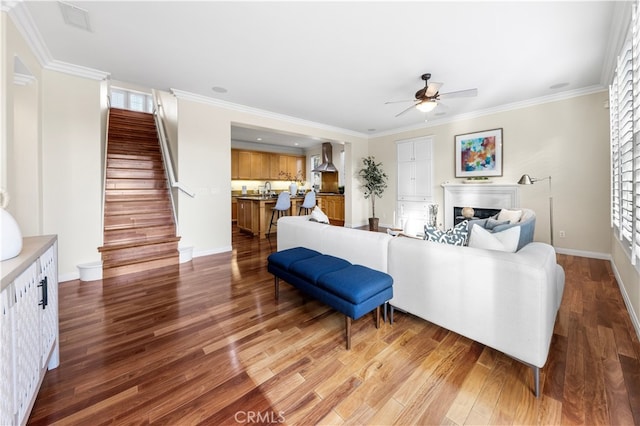 living room featuring hardwood / wood-style flooring, ceiling fan, and crown molding