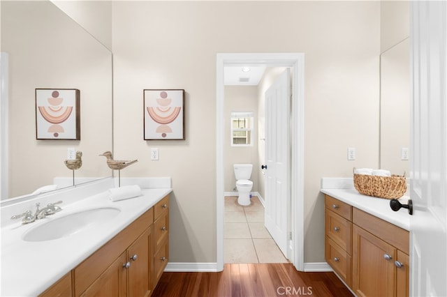 bathroom with vanity, toilet, and wood-type flooring