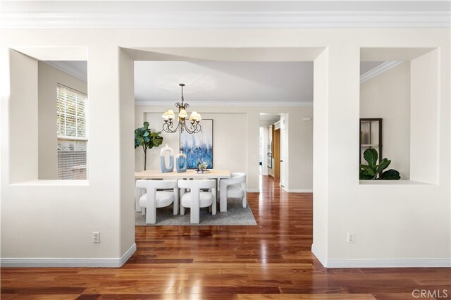 dining area featuring crown molding, a chandelier, and dark wood-type flooring