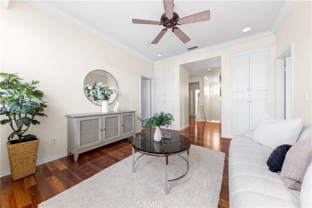 living room with ornamental molding, dark hardwood / wood-style floors, and ceiling fan