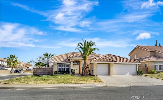 mediterranean / spanish house featuring a garage and a front lawn