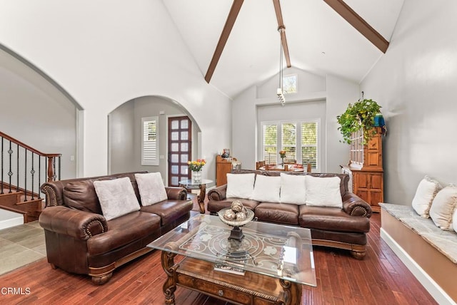 living room with dark wood-type flooring, high vaulted ceiling, and beamed ceiling