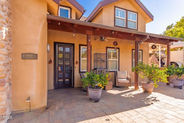 doorway to property with ceiling fan and a patio area