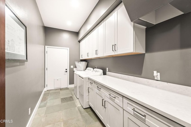 clothes washing area featuring cabinets and washing machine and clothes dryer