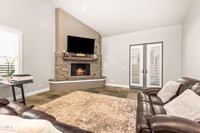 living room with a stone fireplace and high vaulted ceiling