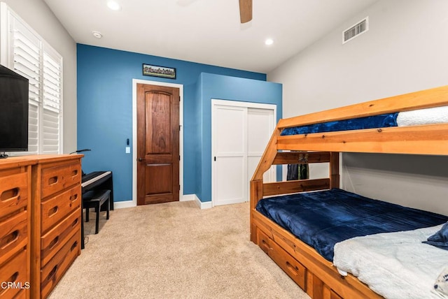 bedroom with light carpet, a closet, and ceiling fan