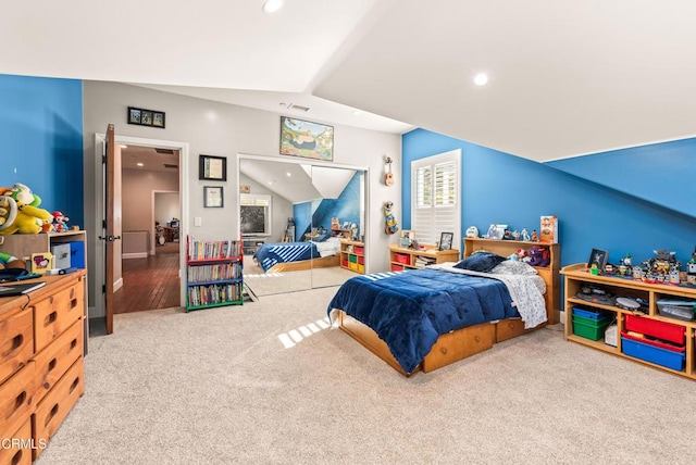 bedroom with vaulted ceiling, carpet, and a closet