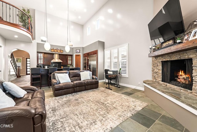 living room with a fireplace and a high ceiling