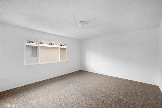 carpeted empty room with a textured ceiling