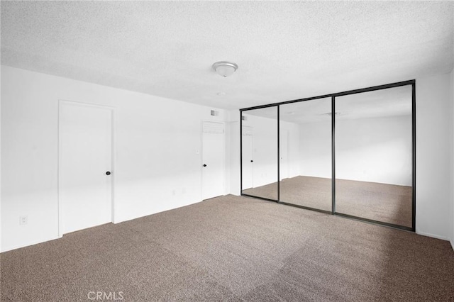 unfurnished bedroom featuring carpet flooring, a closet, and a textured ceiling