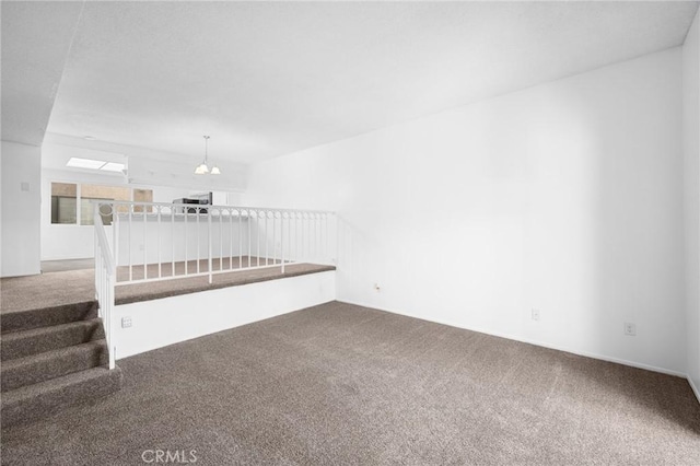 unfurnished living room with a notable chandelier and carpet floors