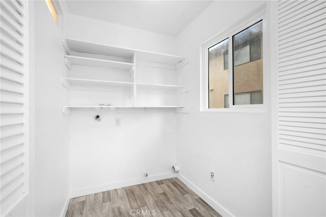 washroom featuring hookup for a gas dryer and light hardwood / wood-style floors