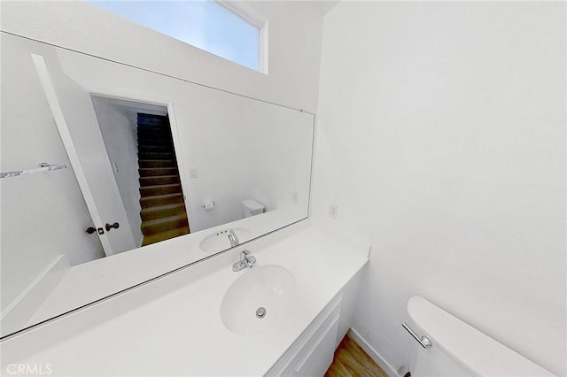 bathroom featuring vanity, hardwood / wood-style flooring, and toilet