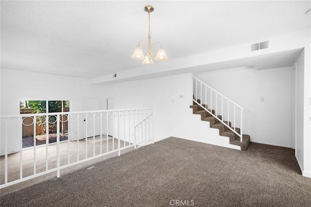 carpeted spare room featuring a notable chandelier